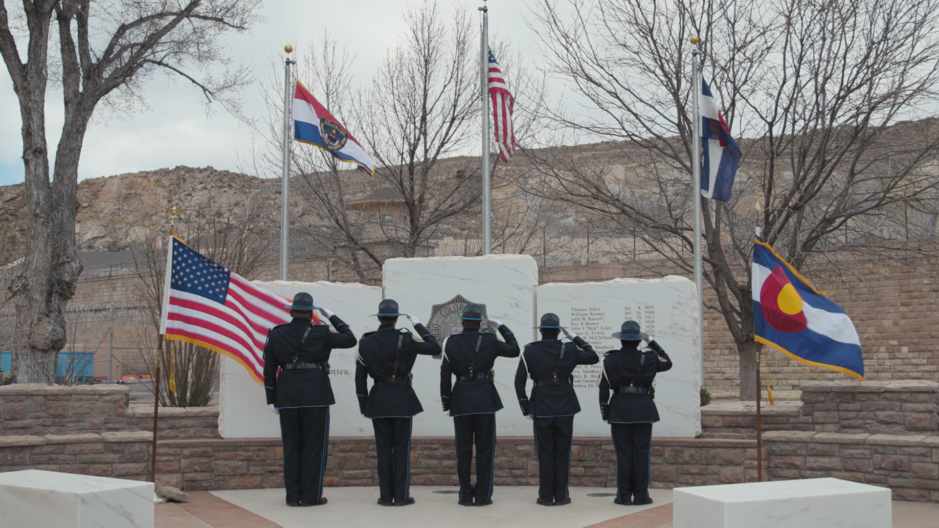 5 members of the Honor Guard salute the flag